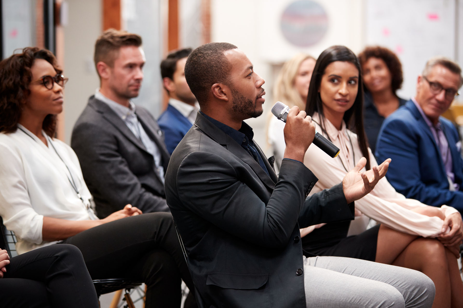 Group Of Businessmen And Businesswomen Applauding Presentation At Conference